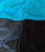Close-up of the turquoise terry and black water-resistant fabrics on a Leapy changing robe