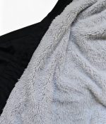 Close-up of soft grey Sherpa lining inside a black Leapy waterproof changing robe