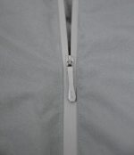 Close-up of the high-quality metal zipper on the white Leapy waterproof jacket, showcasing a sleek design with smooth gliding for easy ventilation adjustment during outdoor activities.
