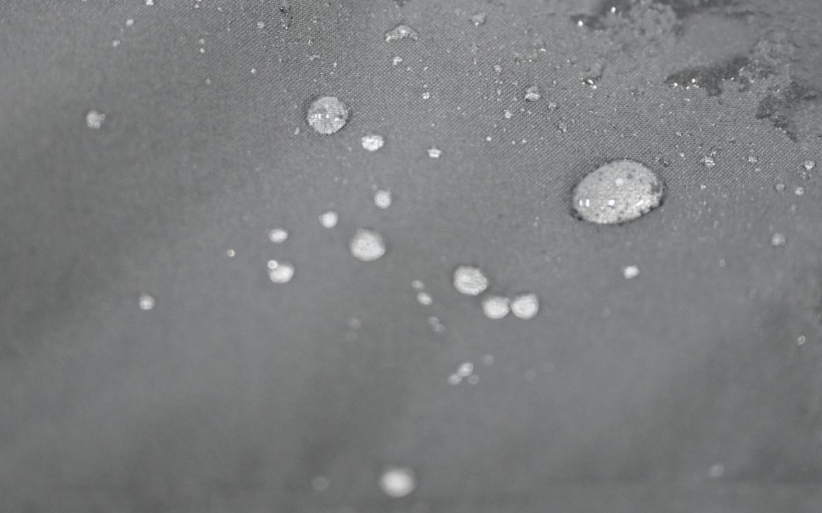 Water droplets beading on LEAPY DWR coated waterproof membrane fabric surface for workwear protection.
